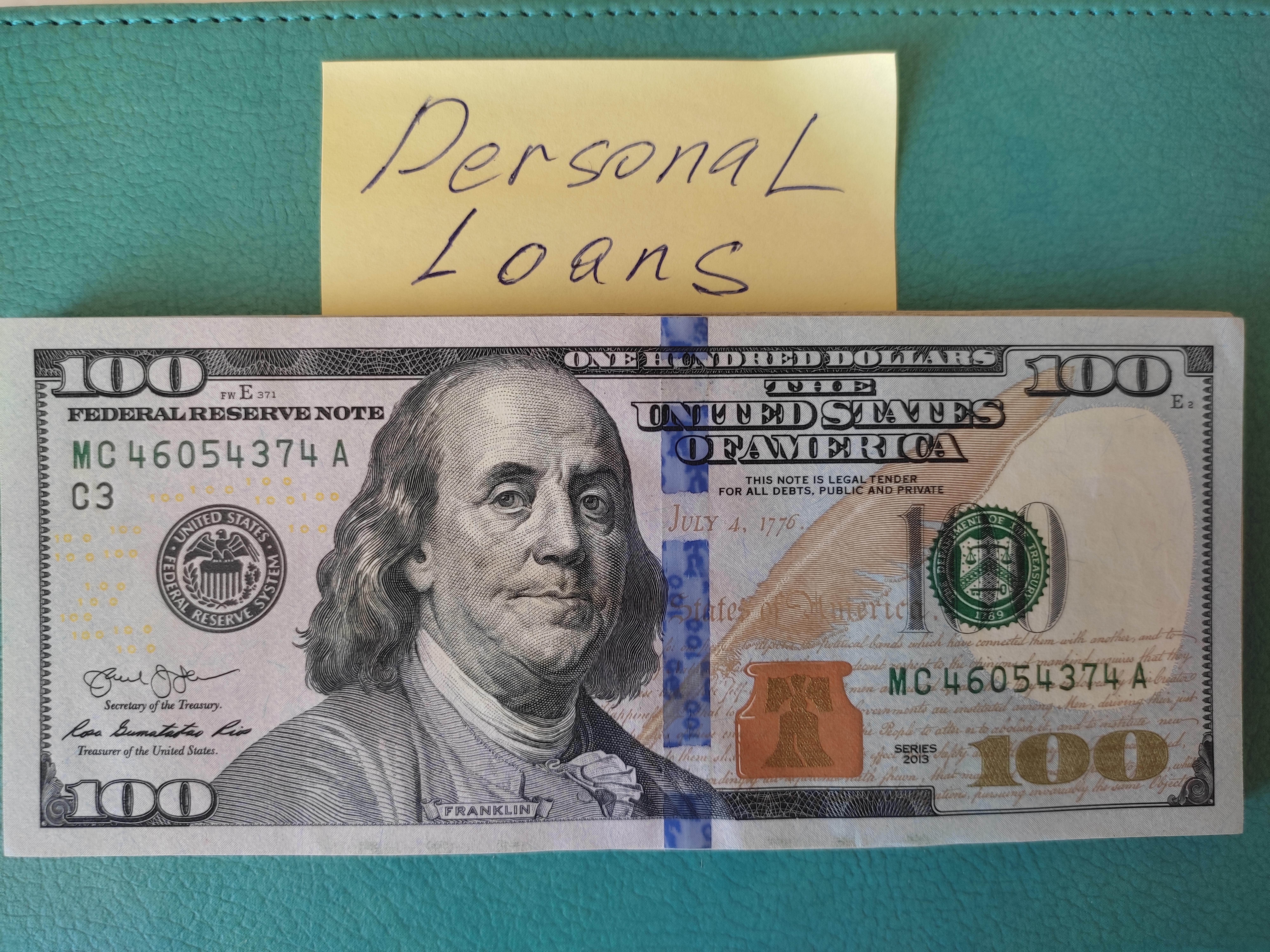 There are dollars on the table and a sticker with the inscription personal loans.